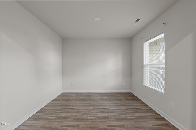 spare room with dark wood-style floors, baseboards, and visible vents