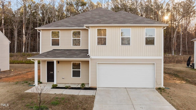 view of front of house featuring driveway, roof with shingles, and an attached garage