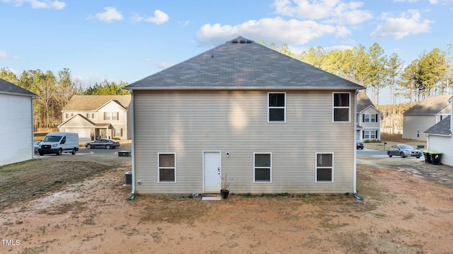 back of house featuring a shingled roof