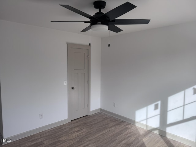 empty room featuring ceiling fan, wood finished floors, and baseboards