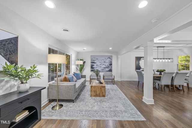 living room featuring recessed lighting, decorative columns, baseboards, and wood finished floors