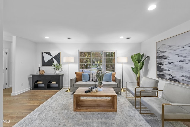 living room featuring baseboards, wood finished floors, and recessed lighting