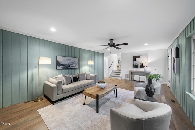 living area featuring stairs, visible vents, and wood finished floors