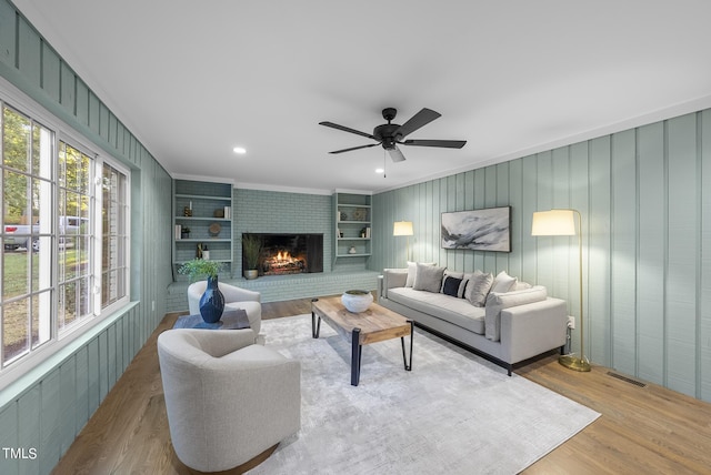 living area featuring a fireplace, recessed lighting, visible vents, ceiling fan, and wood finished floors