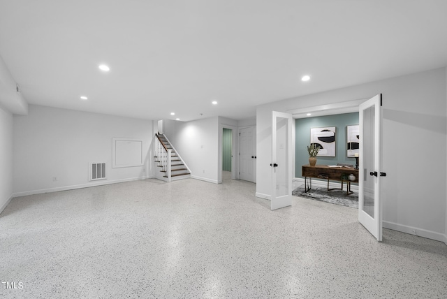 below grade area featuring recessed lighting, visible vents, baseboards, french doors, and stairway