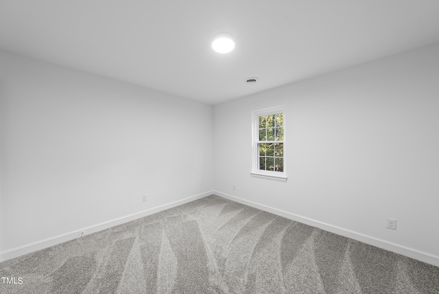 carpeted spare room with baseboards and visible vents