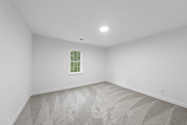 carpeted spare room featuring baseboards