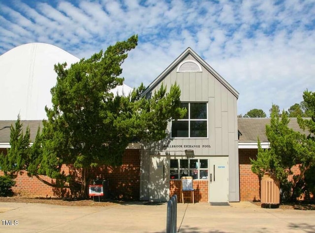 view of front facade featuring board and batten siding and brick siding