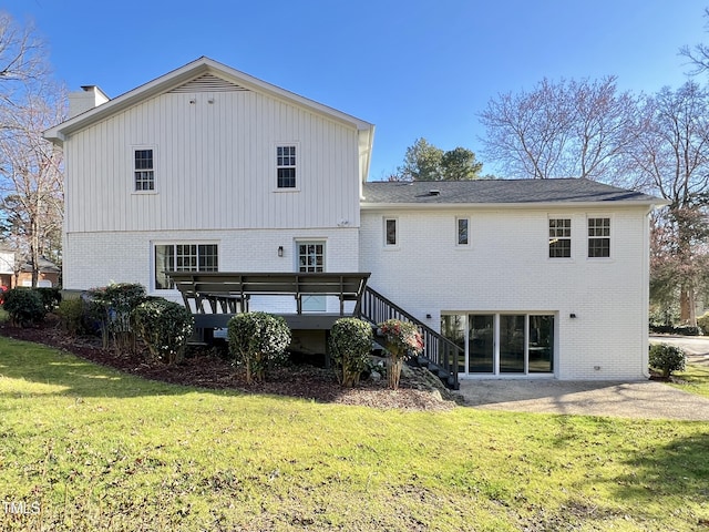 rear view of house featuring a yard, brick siding, and a patio area