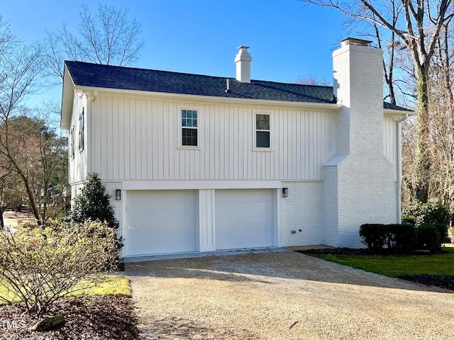 view of property exterior with driveway, an attached garage, a chimney, and brick siding