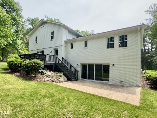 back of property with stairs, brick siding, a yard, and a patio