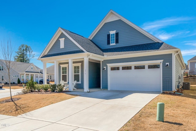 view of front facade with a porch, concrete driveway, a shingled roof, and a garage