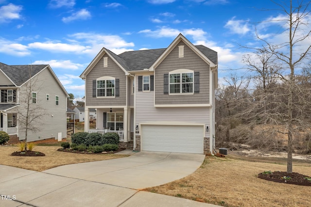 traditional home featuring central air condition unit, a porch, a garage, stone siding, and driveway