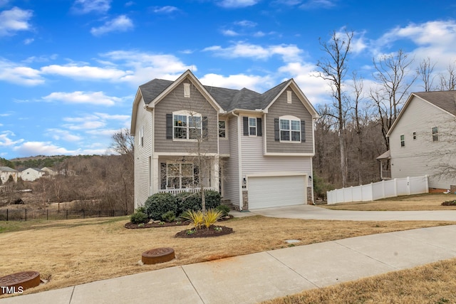 traditional home featuring covered porch, driveway, an attached garage, and fence