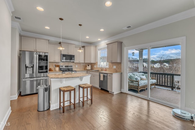 kitchen featuring tasteful backsplash, visible vents, appliances with stainless steel finishes, crown molding, and a sink