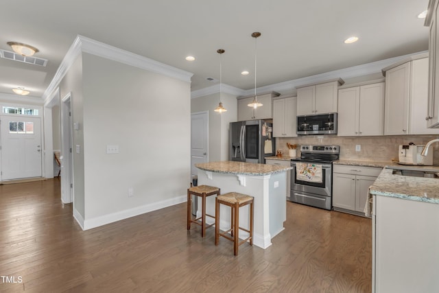 kitchen featuring visible vents, appliances with stainless steel finishes, dark wood-style flooring, a center island, and a sink