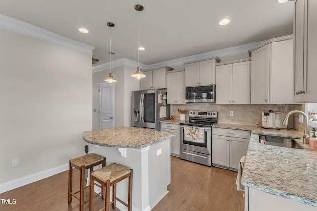 kitchen featuring light wood finished floors, tasteful backsplash, stainless steel appliances, and a sink