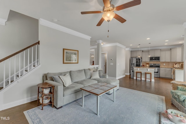 living area with ornamental molding, dark wood-style flooring, stairway, and baseboards