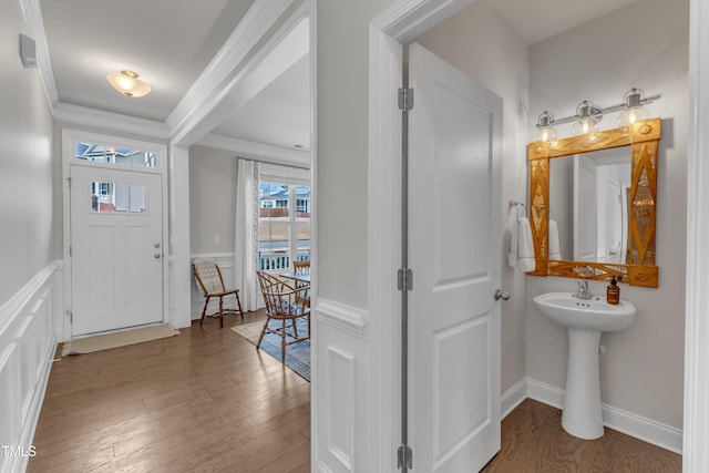 entrance foyer with baseboards, wood finished floors, and crown molding