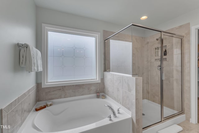 bathroom with a stall shower, a garden tub, and recessed lighting