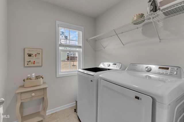 washroom with washer and dryer, laundry area, and baseboards