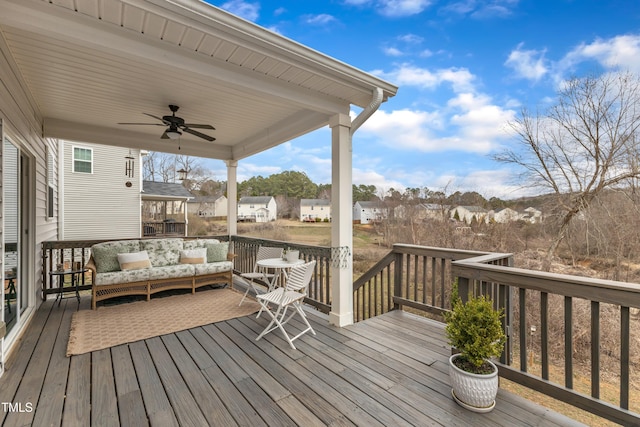 wooden deck with ceiling fan, a residential view, and an outdoor living space