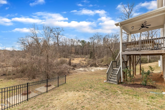 view of yard featuring stairs, fence, and a ceiling fan