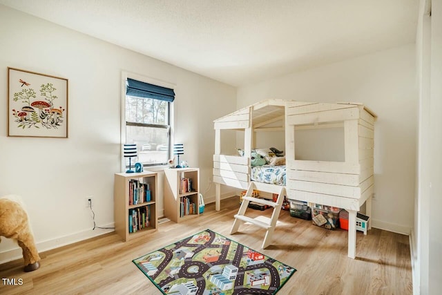 bedroom with baseboards and wood finished floors