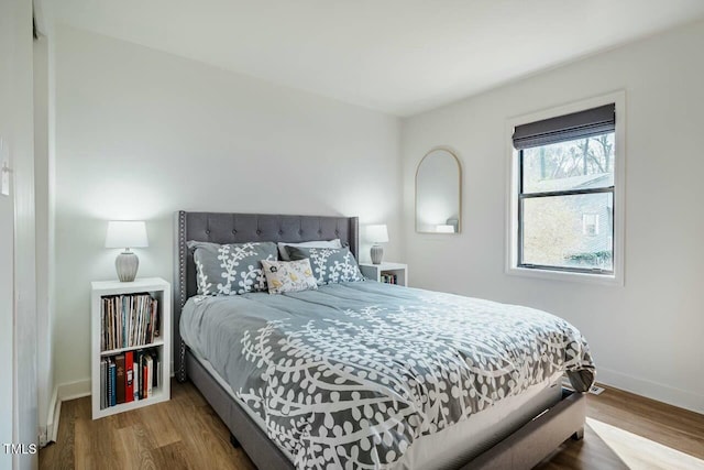 bedroom featuring baseboards and wood finished floors