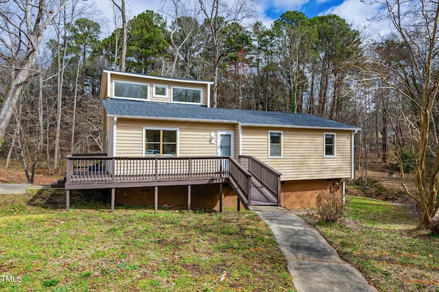 view of front of house with stairs, a front lawn, and a wooden deck