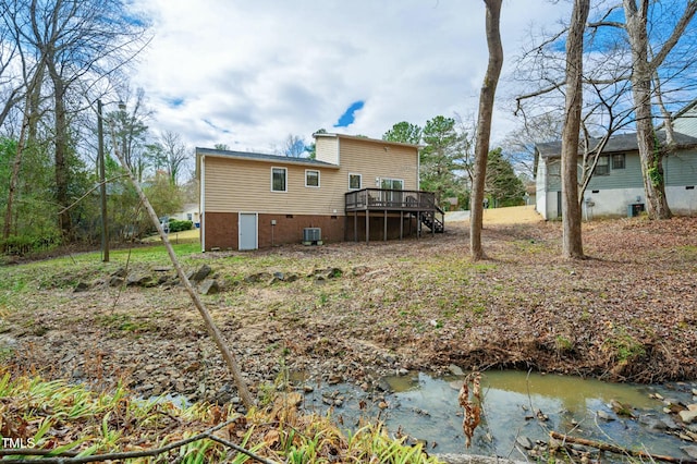 rear view of property featuring a deck, stairs, and central air condition unit