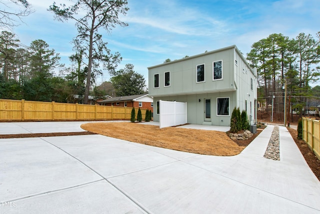 back of property featuring a fenced backyard, board and batten siding, and a patio