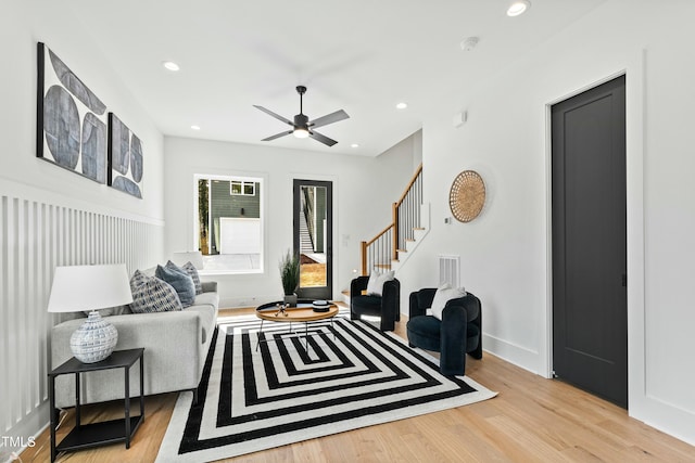 living room featuring recessed lighting, visible vents, baseboards, light wood-style floors, and stairway