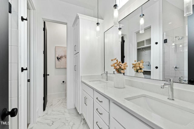 full bath featuring marble finish floor, double vanity, a sink, and a shower stall