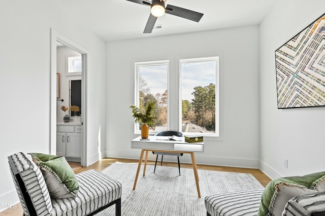 office with a ceiling fan, baseboards, visible vents, and light wood finished floors