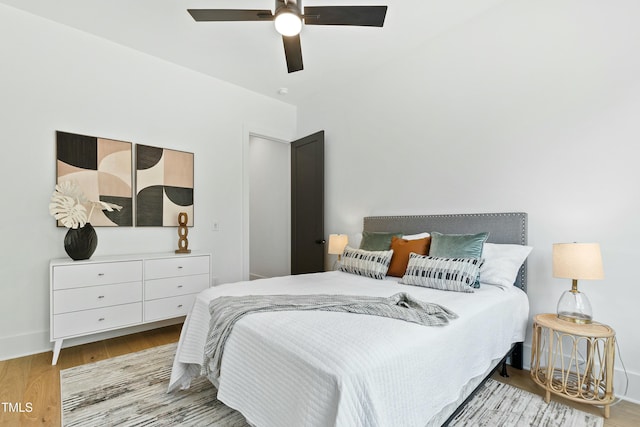 bedroom with a ceiling fan, baseboards, and wood finished floors