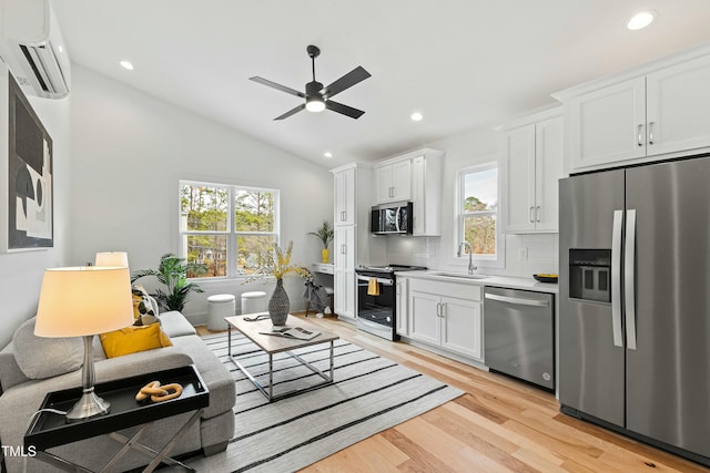 living room featuring light wood-style flooring, recessed lighting, a ceiling fan, vaulted ceiling, and a wall mounted air conditioner