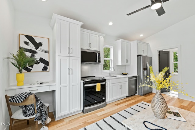 kitchen with decorative backsplash, appliances with stainless steel finishes, light countertops, white cabinetry, and a sink