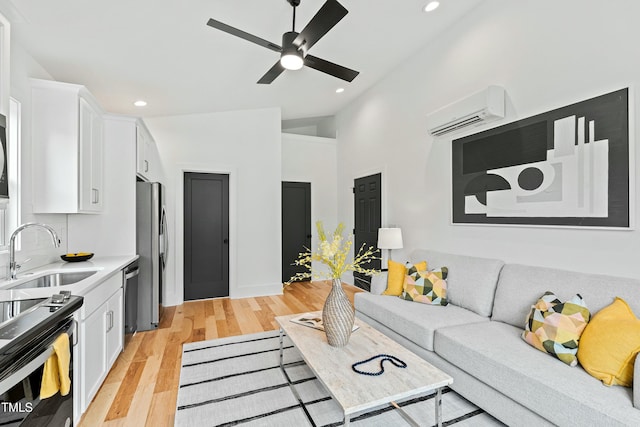 living area featuring recessed lighting, light wood-style flooring, and a wall mounted air conditioner