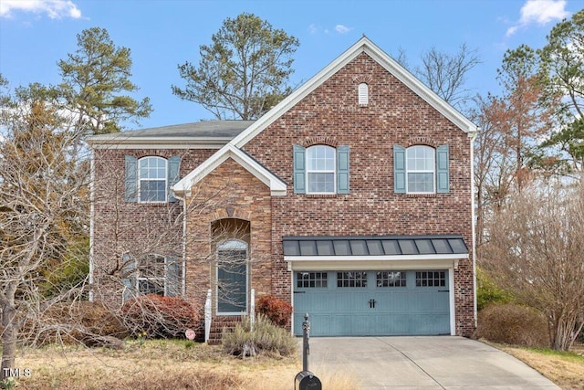 traditional-style house featuring metal roof, a garage, brick siding, concrete driveway, and a standing seam roof