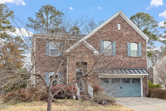 traditional-style house featuring an attached garage, concrete driveway, and brick siding