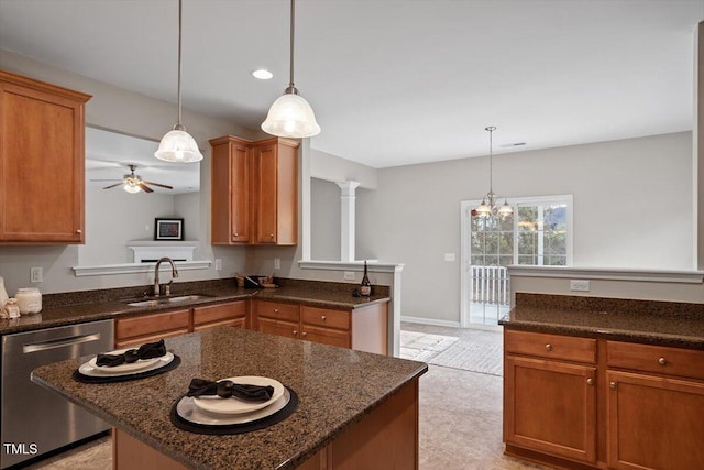 kitchen featuring a sink, stainless steel dishwasher, brown cabinets, a center island, and dark stone counters