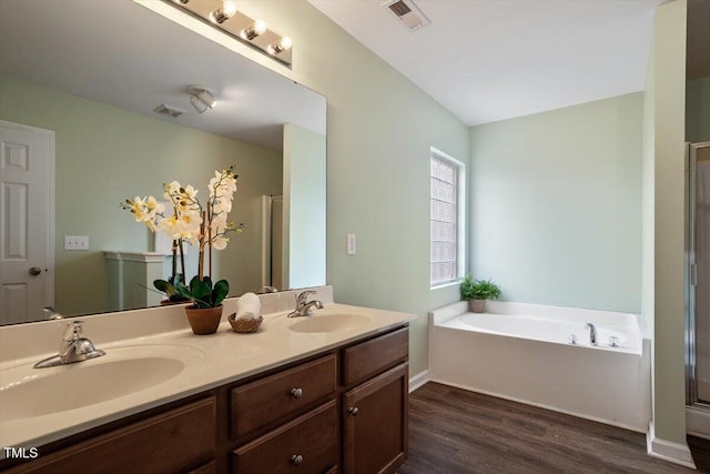 bathroom featuring a bath, a sink, visible vents, and a shower stall