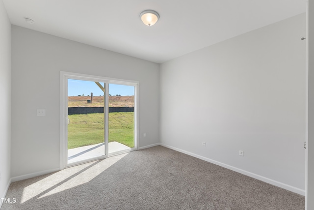 spare room featuring carpet floors and baseboards