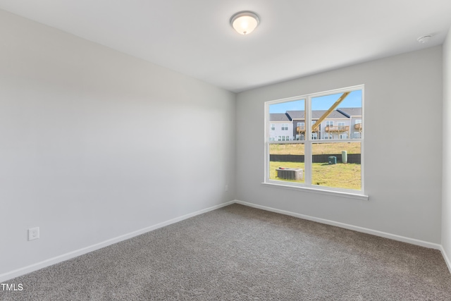 spare room featuring carpet flooring and baseboards