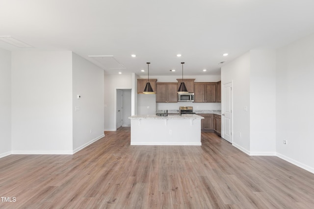 kitchen with recessed lighting, stainless steel appliances, baseboards, open floor plan, and light wood finished floors