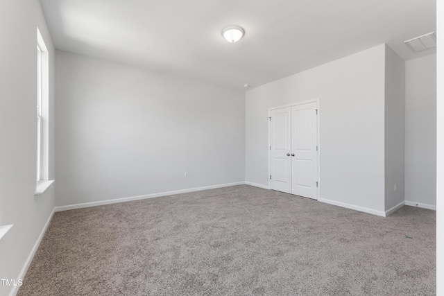 empty room with carpet and baseboards