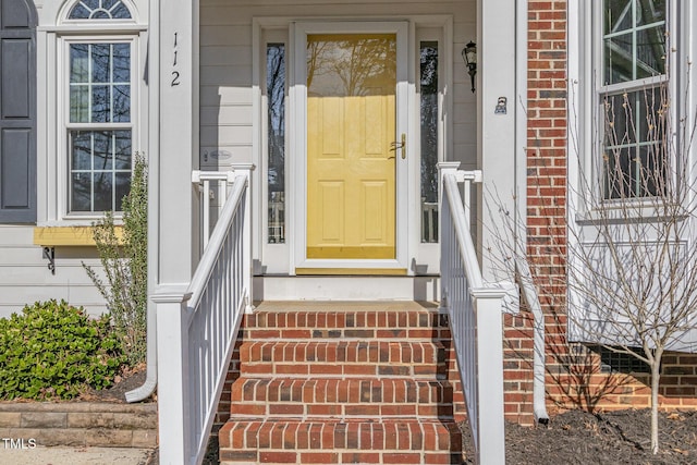 doorway to property featuring brick siding