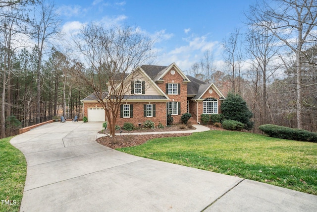 view of front of house with a front yard, a garage, brick siding, and driveway