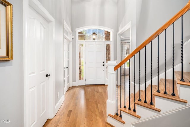 entryway featuring stairway, baseboards, and light wood finished floors